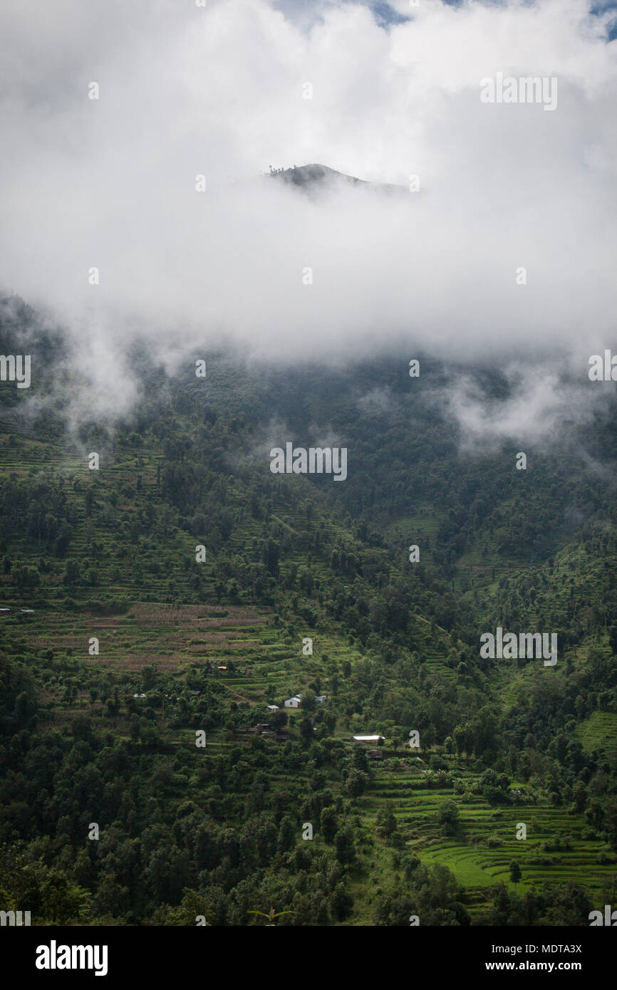 Wide landscape shot of steep, stepped rice terraces and communities in the Dhading District of Nepal Stock Photo
