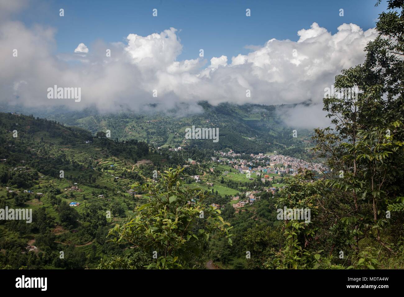 Wide landscape shot of steep, stepped rice terraces and communities in the Dhading District of Nepal Stock Photo