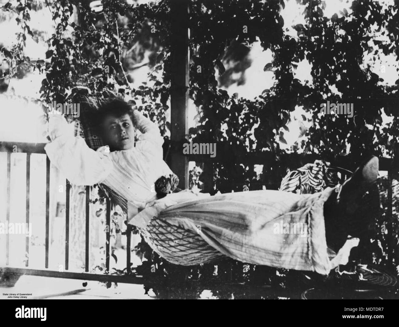 Woman in a hammock on the verandah, Fraser Island, Queensland,. Stock Photo