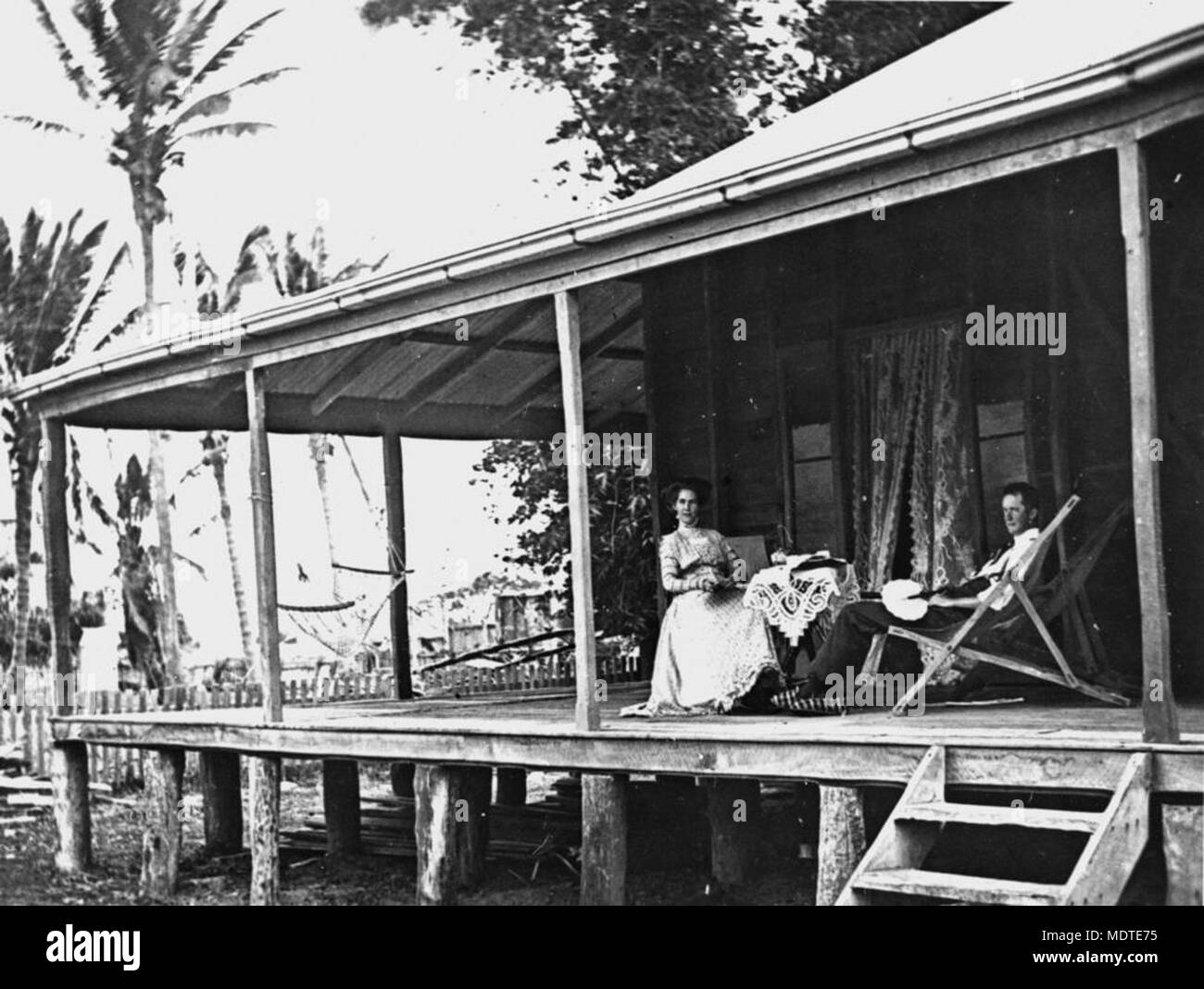 Man and woman relaxing on the verandah of their farmhouse,. Stock Photo