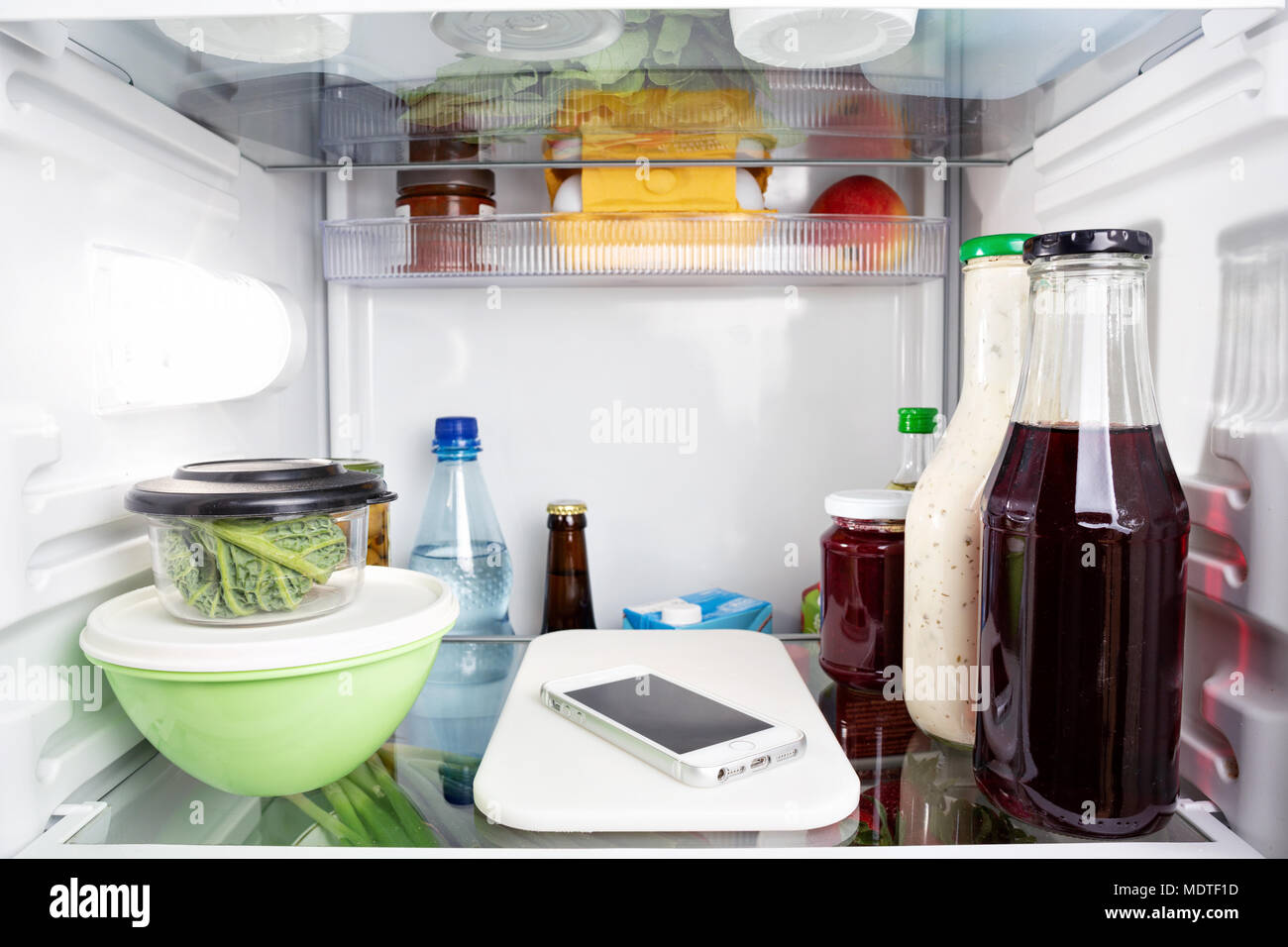 Misplaced mobile phone inside a fridge Stock Photo