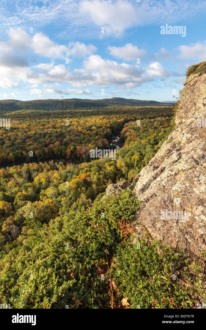 The Big Carp River cuts a swath through an autumn colored forest. Viewed from a rocky bluff on a hiking trail at Porcupine Mountains Wilderness Area,  Stock Photo