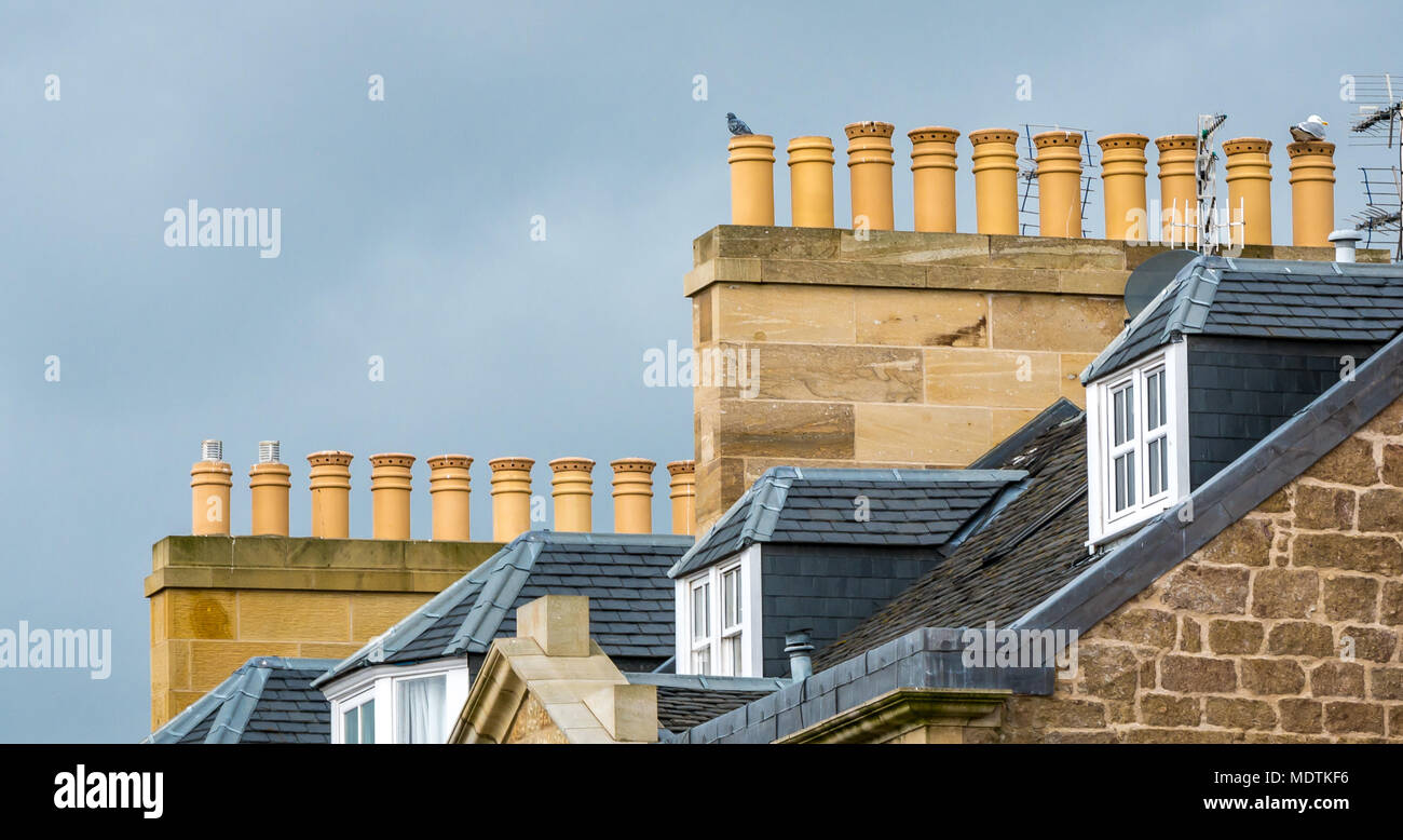 Close up view chimney pots on old stone buildings with slate roof and dormer windows, Haddington, East Lothian, Scotland, UK Stock Photo