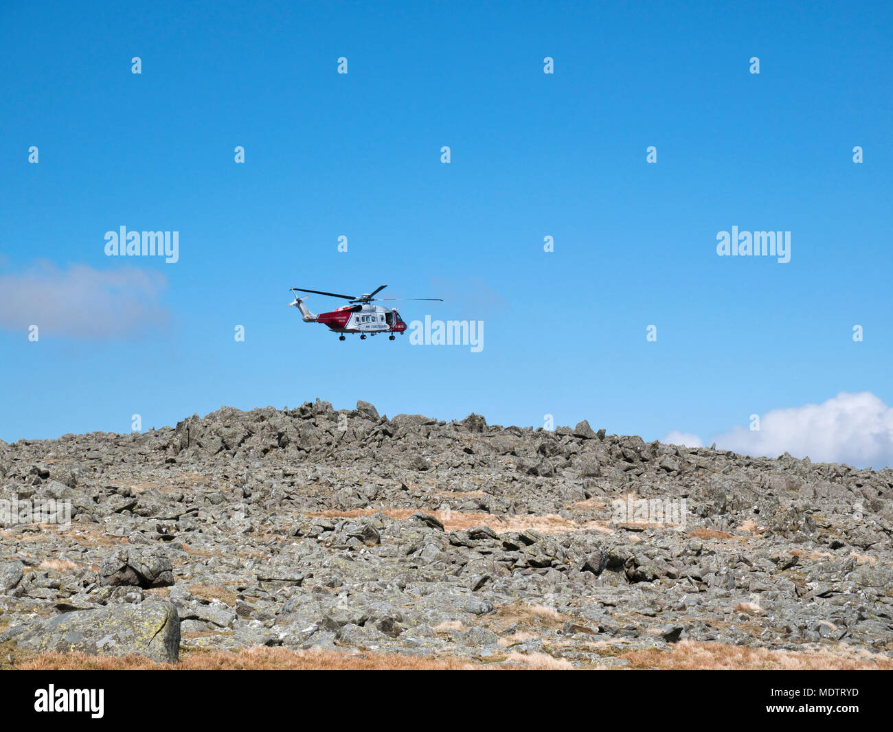 North Wales coastguard helicopter on mountain rescue training exercise over the summit of Carnedd Dafydd in Snowdonia National Park Stock Photo