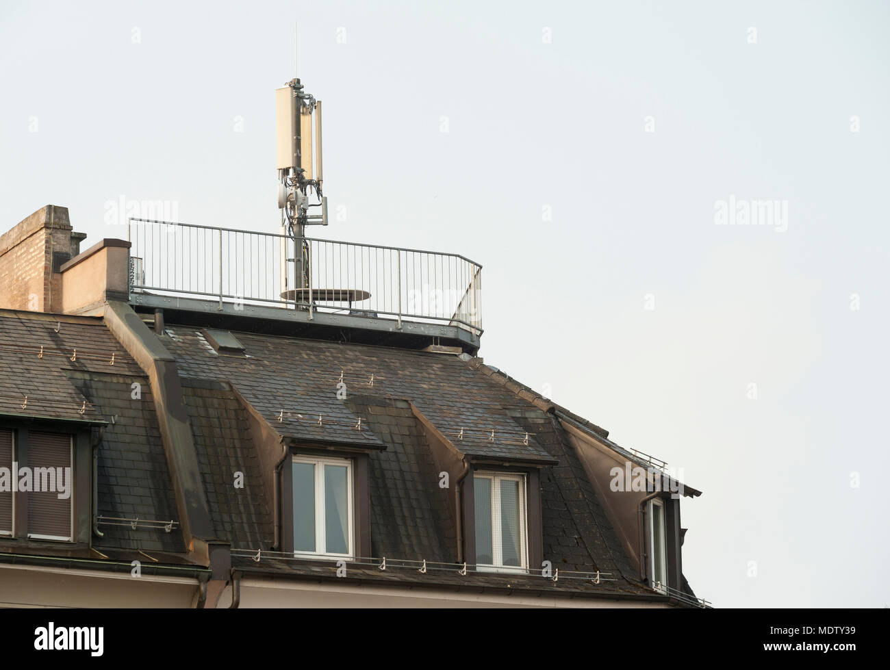 Zurich, Switzerland - 7 March 2014: Mobile phone antenna on top of an apartment house in a residential area of Zurich, Switzerland. Scientists warn ab Stock Photo