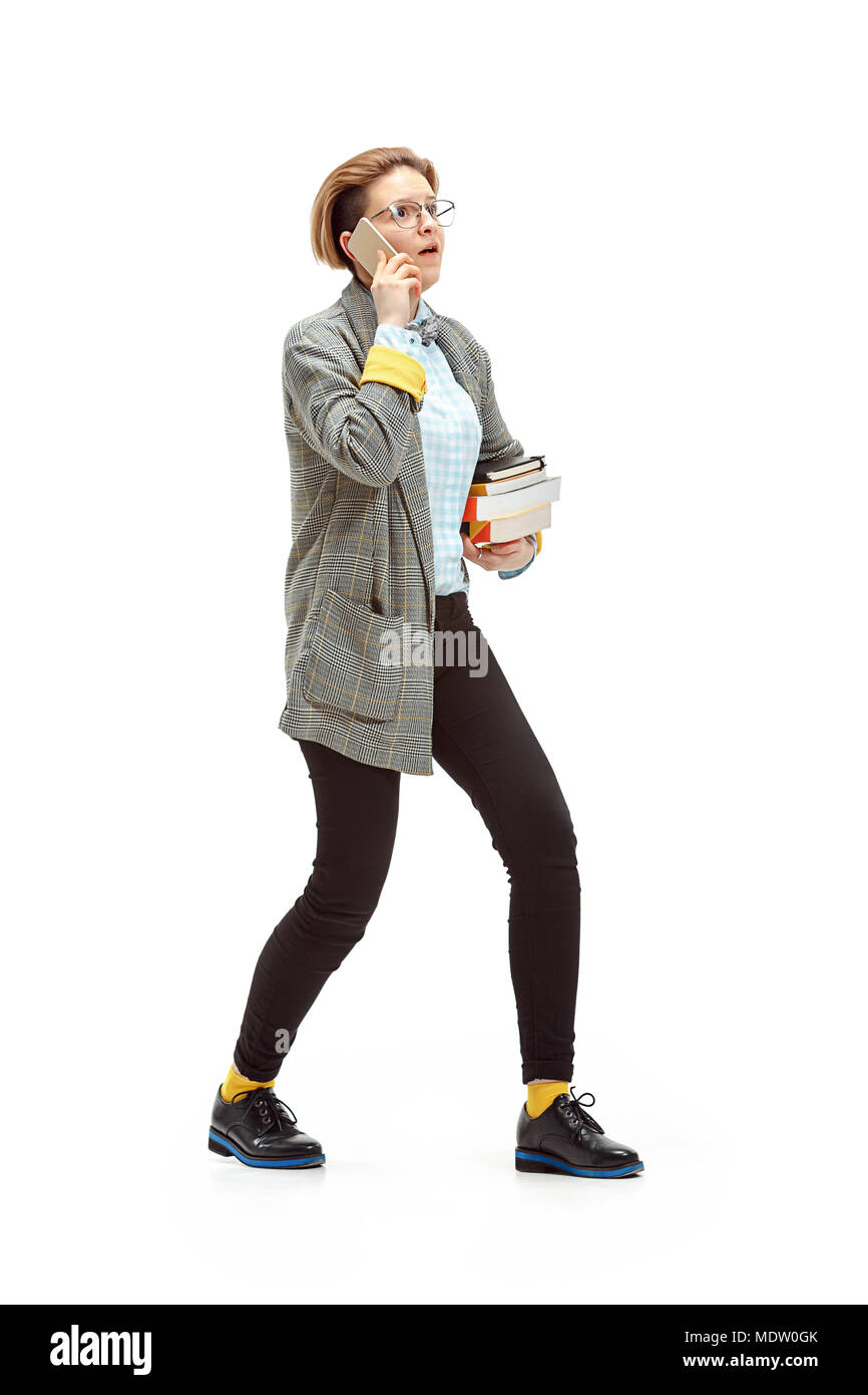 Full length portrait of a surprised female student holding books ...