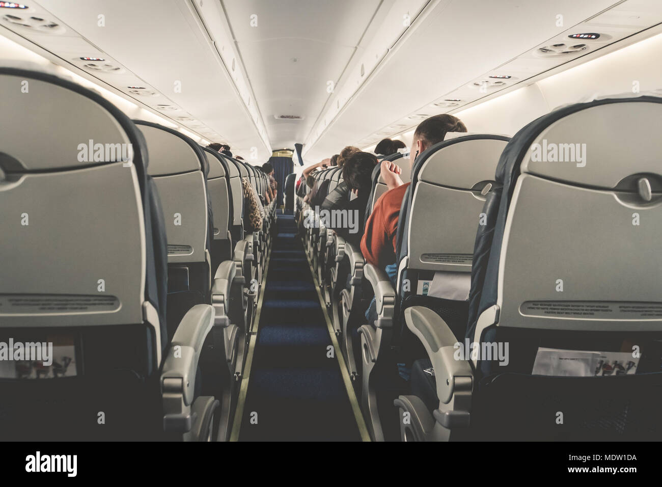 Interior of airplane with passengers on seats waiting to taik off.  Horizontal composition. boring flight in economy class aircraft salon.  economy clas Stock Photo - Alamy