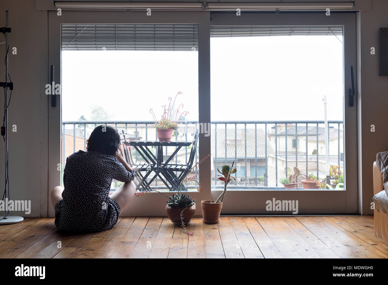 sad woman sitting and looking out the window Stock Photo - Alamy