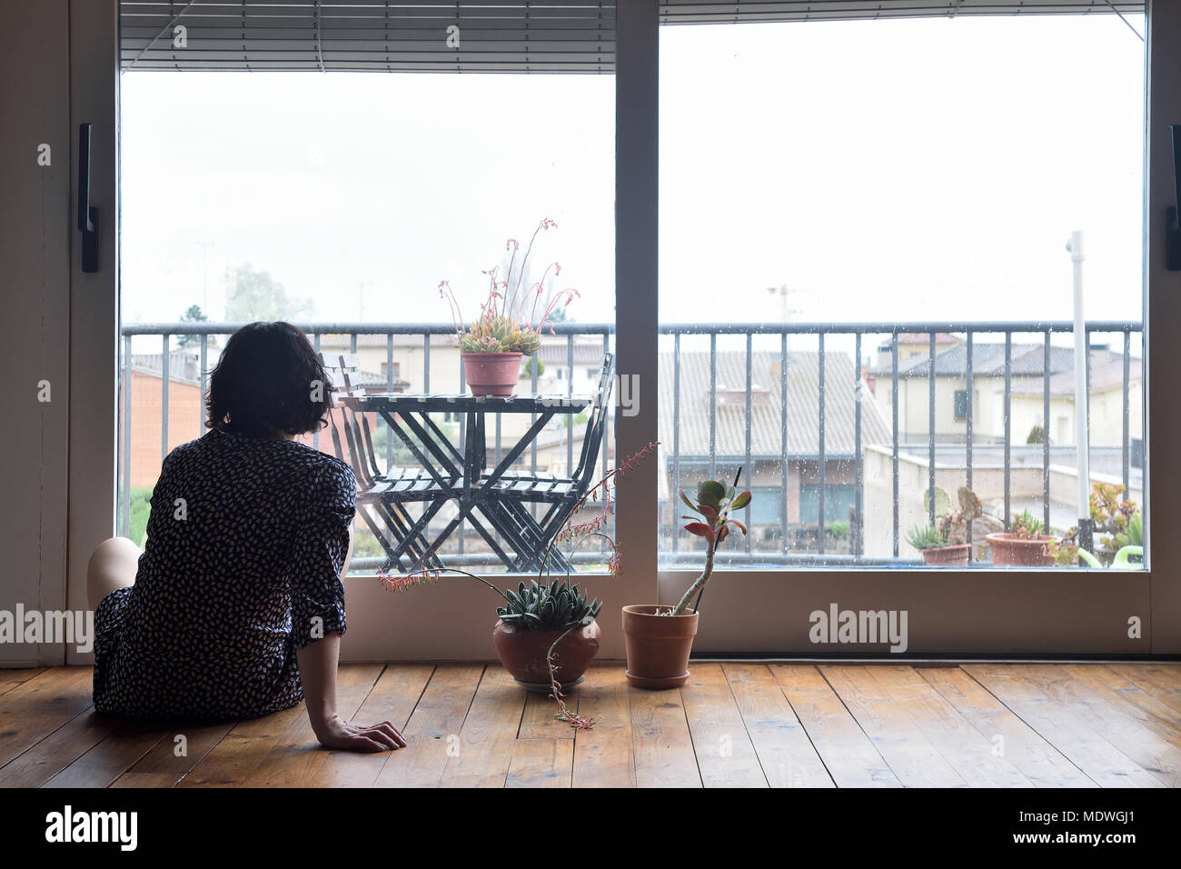 sad woman sitting and looking out the window Stock Photo - Alamy