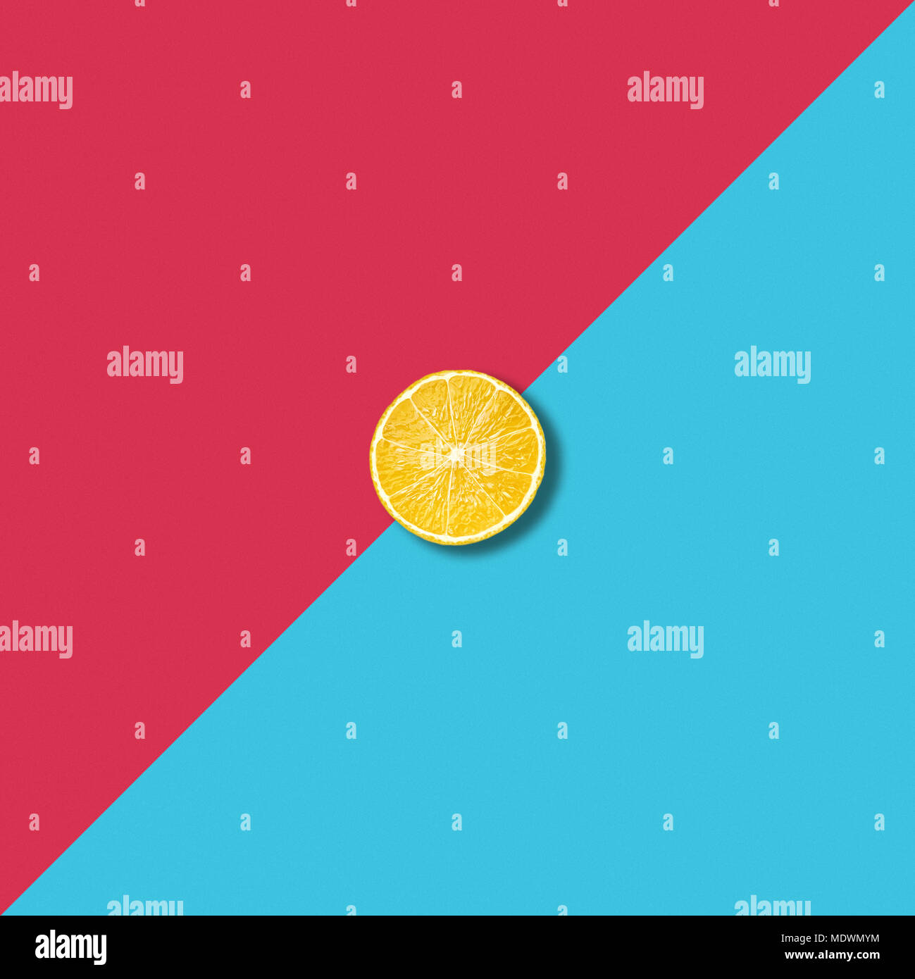 Minimalist abstract illustration with single lemon slice on vibrant red and turquoise background Stock Photo