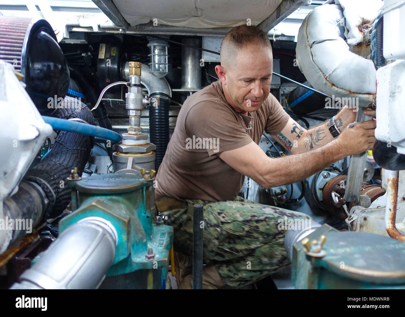 171204-N-FD185-004  CAMP LEMONNIER, Djibouti. (Dec. 6, 2017) Hull Maintenance Technician 1st Class Matthew McCarthy, assigned to Coastal Riverine Squadron (CRS) 10, inspects the engine compartment of a patrol boat prior to underway operations. CRS-10 is forward-deployed to the U.S. 6th Fleet area of operations and conducts joint and naval operations, often in concert with allied and interagency partners, in order to advance U.S. national interests and security and stability in Europe and Africa. (U.S. Navy photo by Engineman 2nd Class Carlos A. Monsalve/Released) Stock Photo