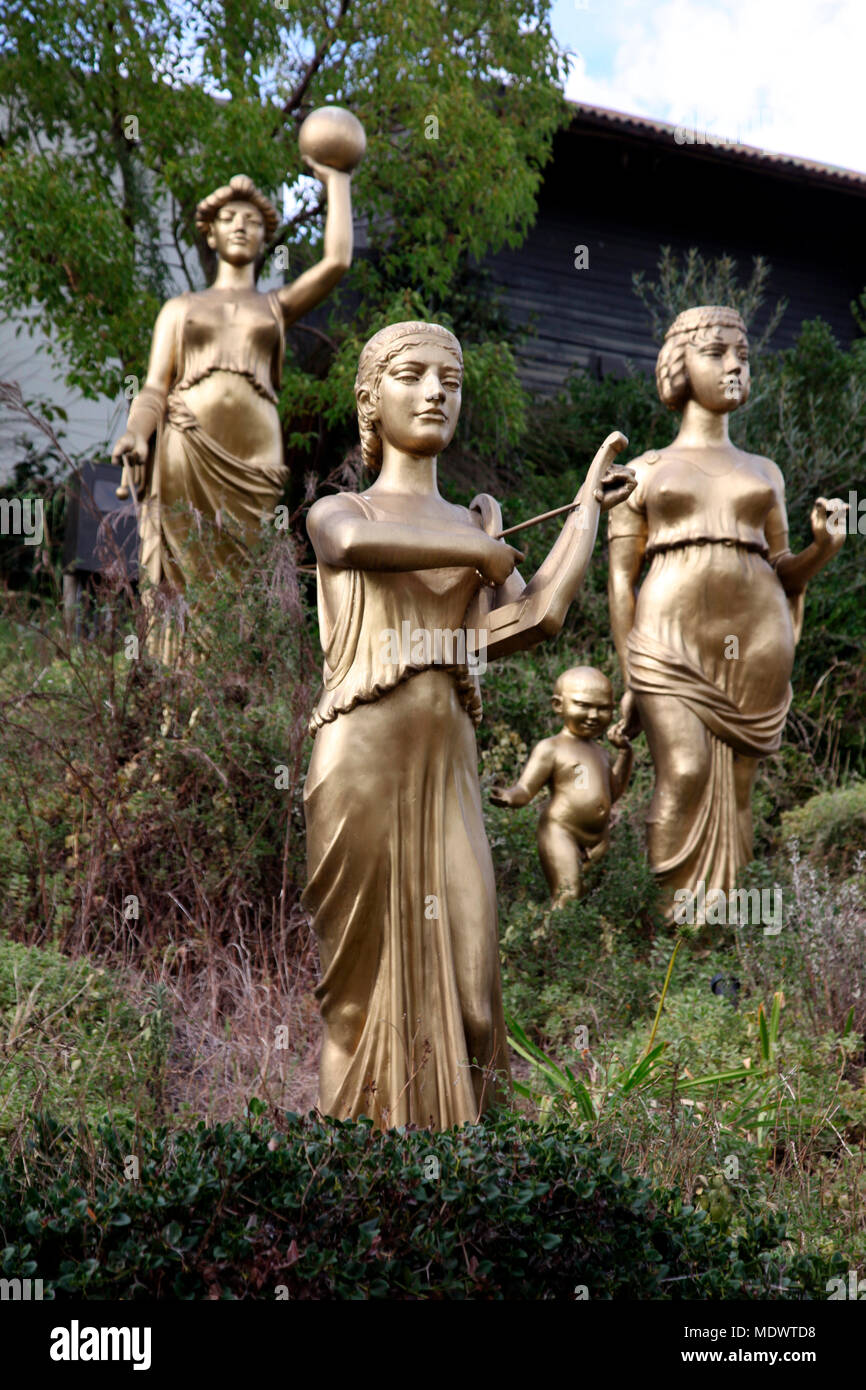Three of the golden statues of the nine Muses in the gardens of the Spier Hotel, that once graced to roof of London’s Barbican Stock Photo
