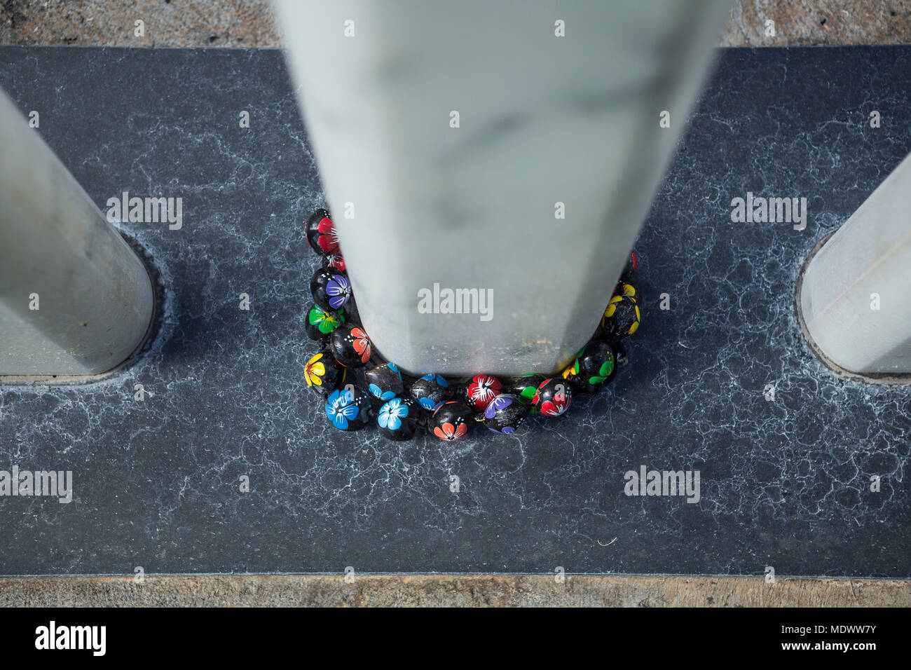 At the close of ceremonies, a Kukui necklace lies around the base of one of the marble monuments dedicated to the Pearl Harbor servicemen who died aboard the USS Oklahoma on December 7, 1940. Kukui were the first prayer beads for the Hawaiian people and are in use today. Stock Photo