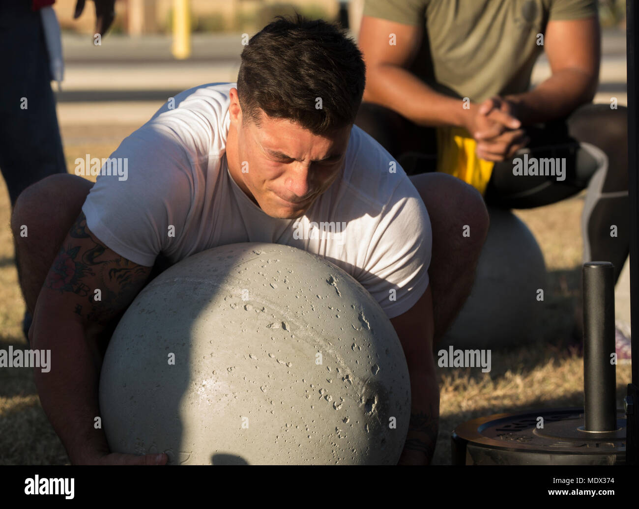 U.S. Marine Corps Cpl. Noah Diaz, an Aviation Ordnance Technician assigned to Marine Aviation Logistics Squadron 13, stationed at Marine Corps Air Station (MCAS) Yuma, Ariz., lifts an Atlas Stone to practice for the Strongman Competition Dec. 15, 2017 on the station parade deck. Atlas Stones are large balls of concrete used to test strength. The practice is to prepare for the Bull of the Desert Strongman Competition slated Feb. 17, 2018 in Yuma, Ariz. (U.S. Marine Corps photo by Lance Cpl. Sabrina Candiaflores) Stock Photo