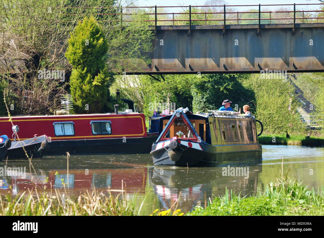 Canal boats / barges at stretch of canal at Enslow Wharf, Bletchingdon, Oxfordshire, UK on a sunny day in Spring Stock Photo