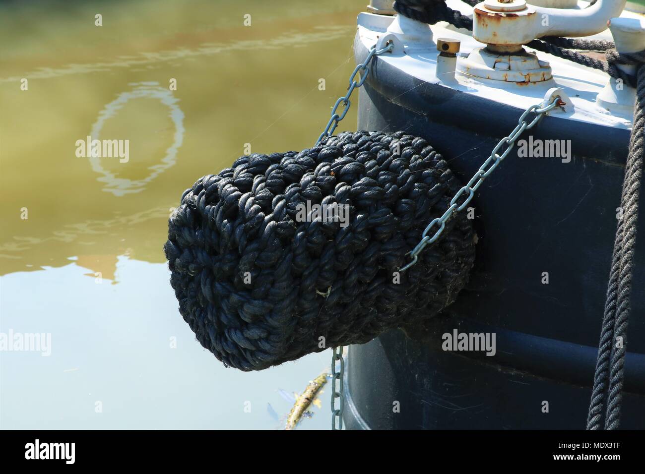Rope bumper on front of canal boat / barge held on by metal chains