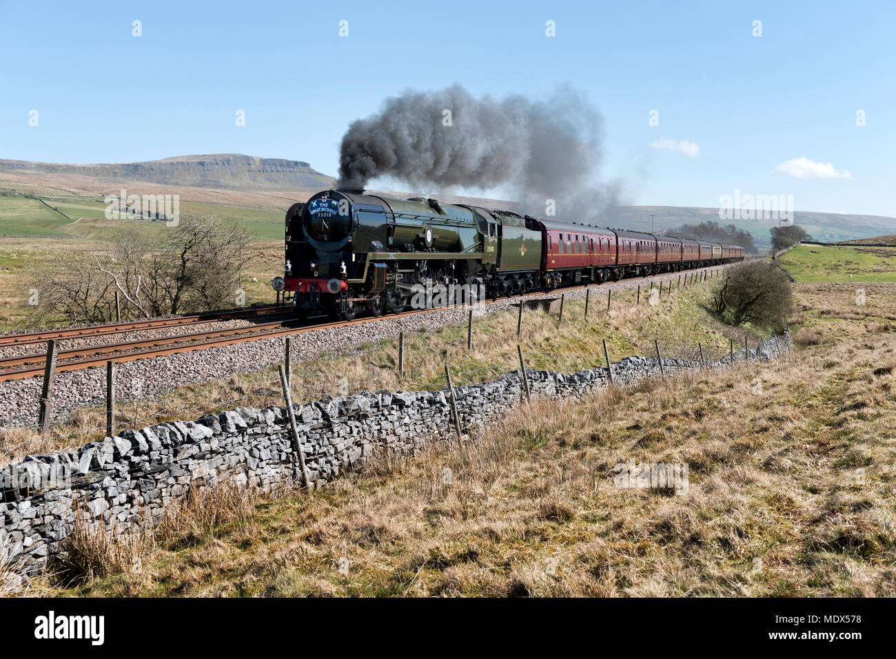 Ribblesdale, North Yorkshire, UK. 20th April 2018. Steam locomotive 'British India Line' hauls The Great Britain XI round the UK rail tour. Seen here on the tour section between York and Carlisle at Selside, in Ribblesdale, on the Settle-Carlisle railway line, 20th April 2018. Built for the Southern Railway in 1945 British India Line is one of the Merchant Navy class locos, all of which were named after shipping lines. The locomotive has been recently restored. In the background is Pen-y-ghent peak in the Yorkshire Dales National Park. Credit: John Bentley/Alamy Live News Stock Photo