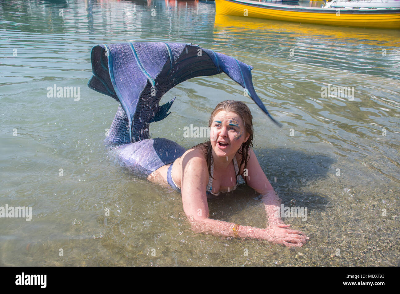 Porthleven, Cornwall, UK. 21st April 2018. UK Weather  It was warm and sunny for  Laura Evans, the St Ives Mermaid, out in the water at the Porthleven Food festival today. Credit: Simon Maycock/Alamy Live News Stock Photo