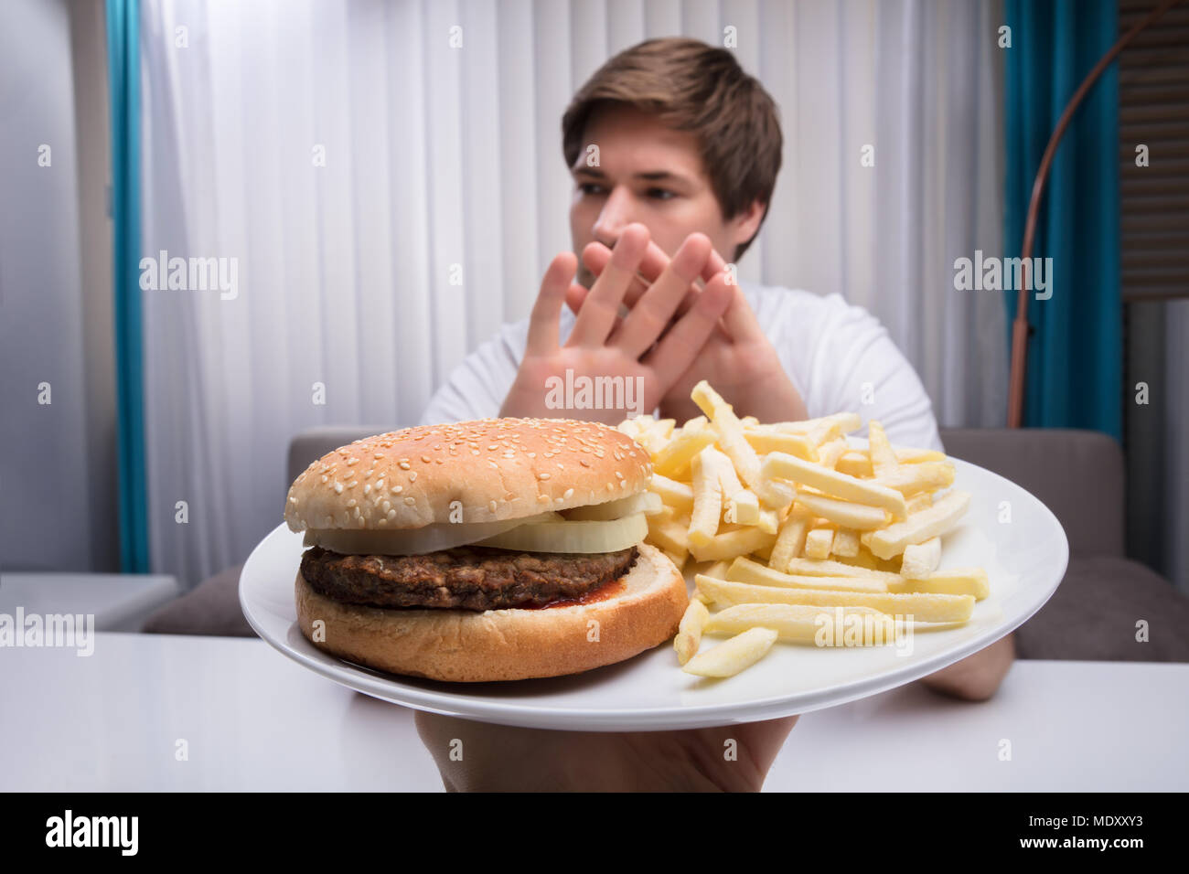 Man Refusing Unhealthy Food Offered By A Person Stock Photo