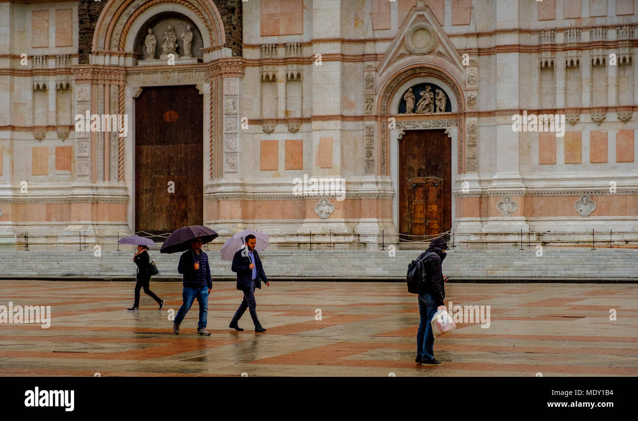People walking in the rain in the early evening outside the Basilica di