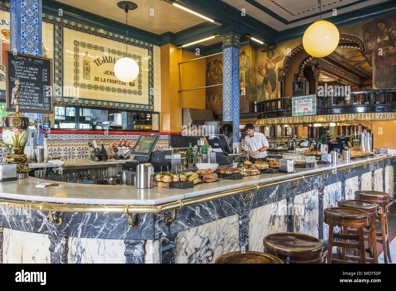 Cafe Iruna and a worker behind the counter with food on display, Bilbao, Spain Stock Photo