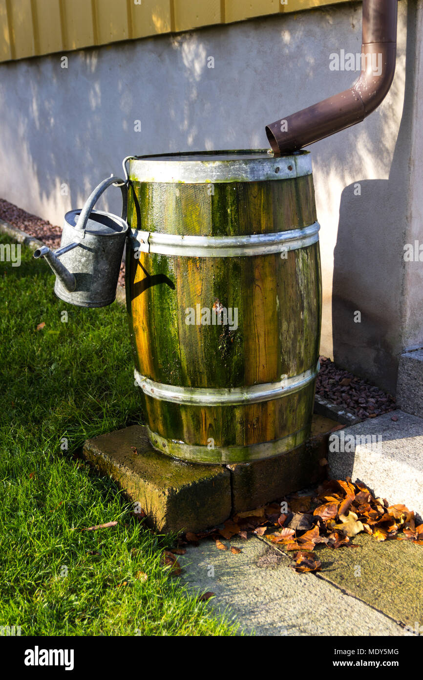 A barrel of rain water next to a house Stock Photo