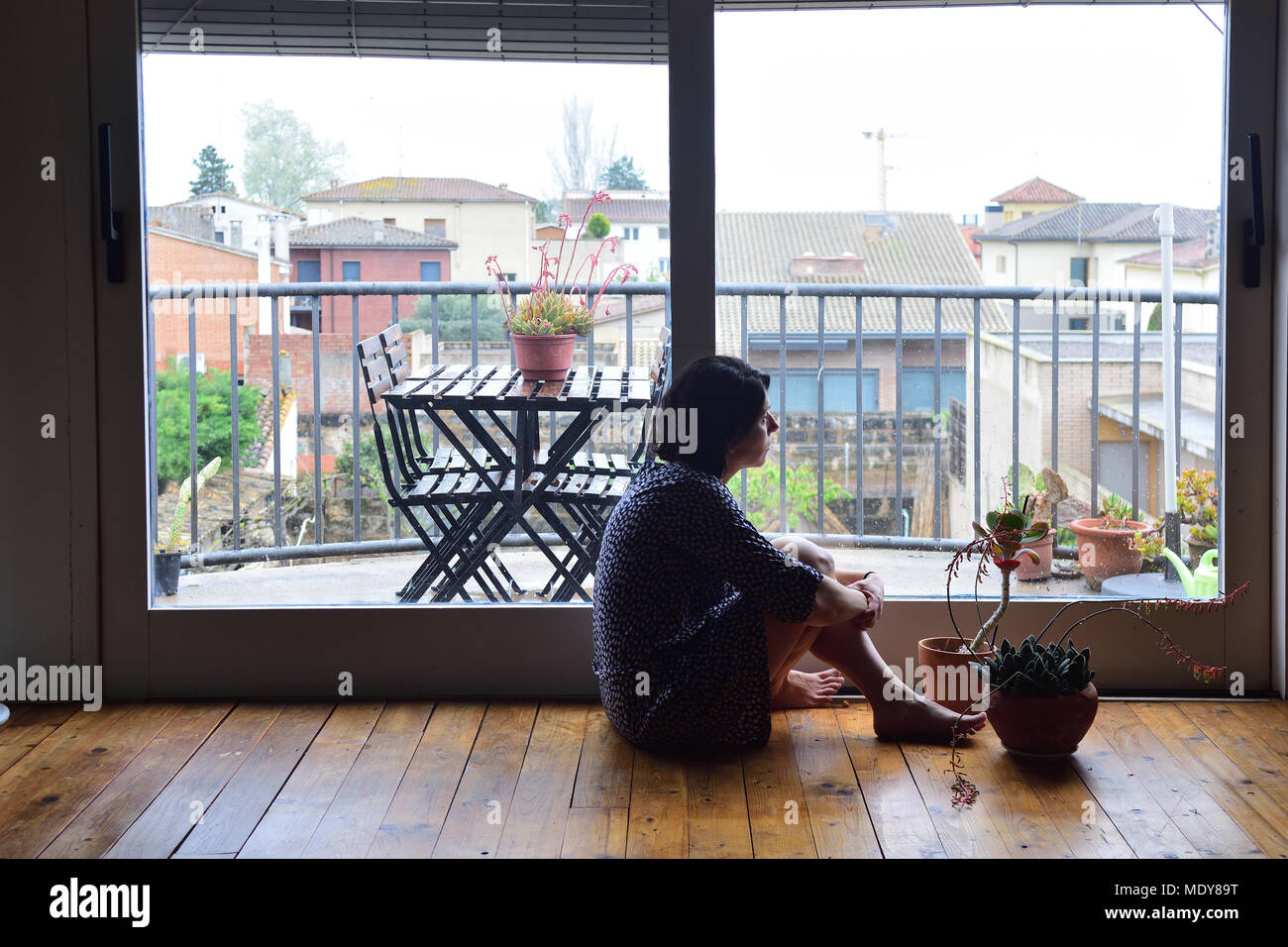 sad woman sitting and looking out the window Stock Photo - Alamy