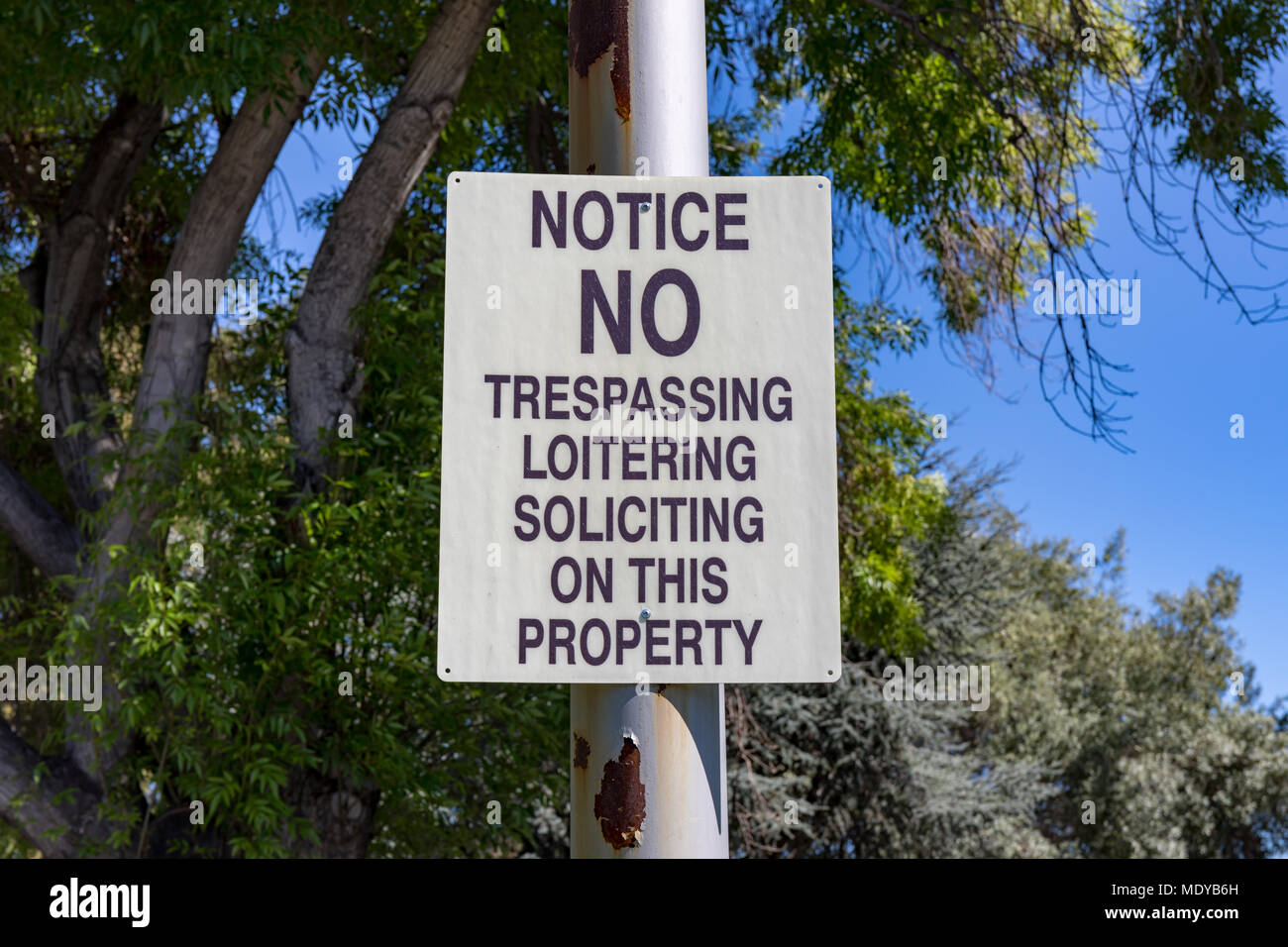 'Notice: No trespassing, loitering, soliciting on this property' sign Stock Photo
