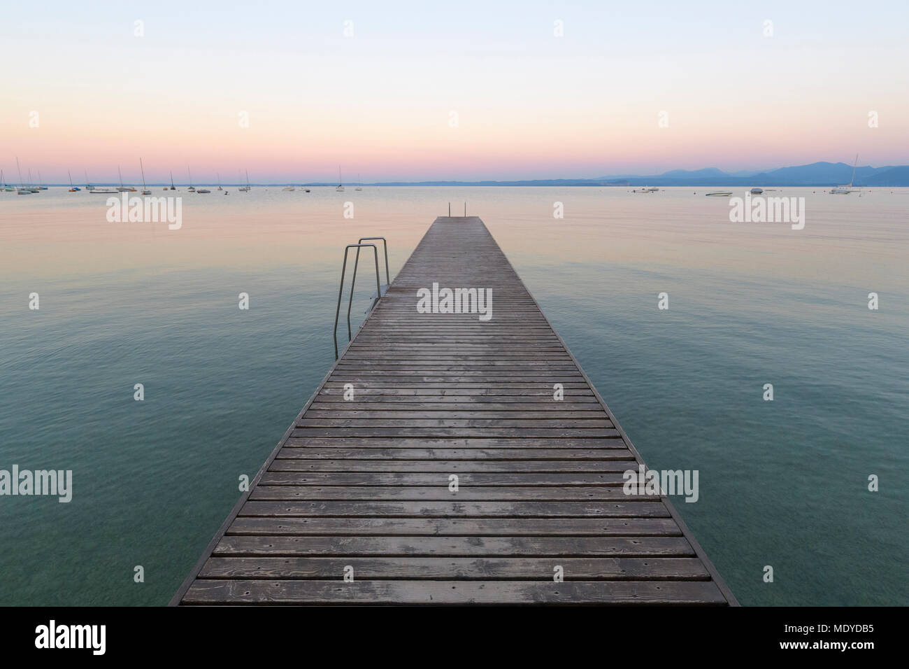 Wooden jetty on Lake Gardo (Lago di Garda) at dawn in Bardolino in Veneto, Italy Stock Photo