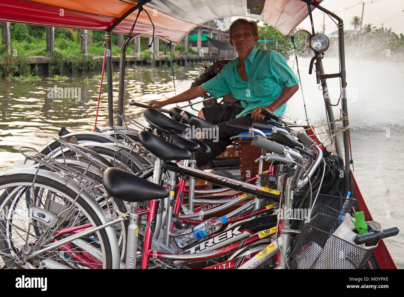Longtail boat carrying tour bicycles on Chao Phraya river, Bangkok, Thailand Stock Photo