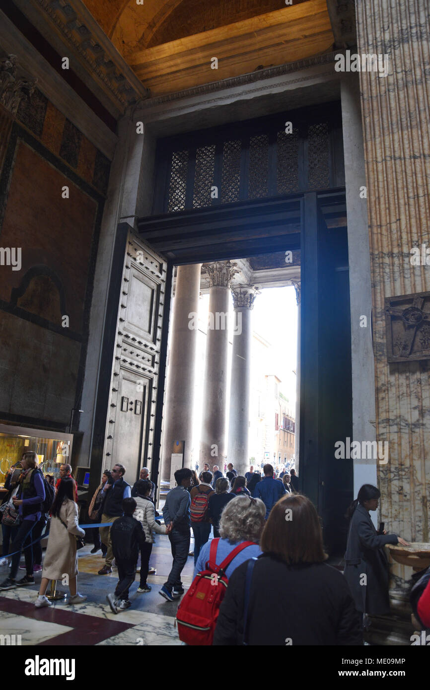 Tourists exit through the large bronze doors from the 15th century. The