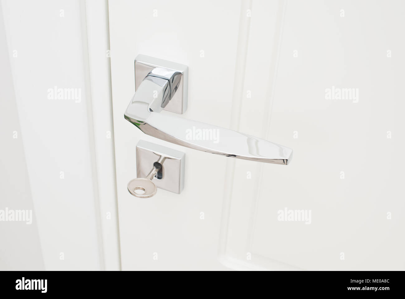 Modern glossy chrome door handle and keyhole with key. Close-up ...