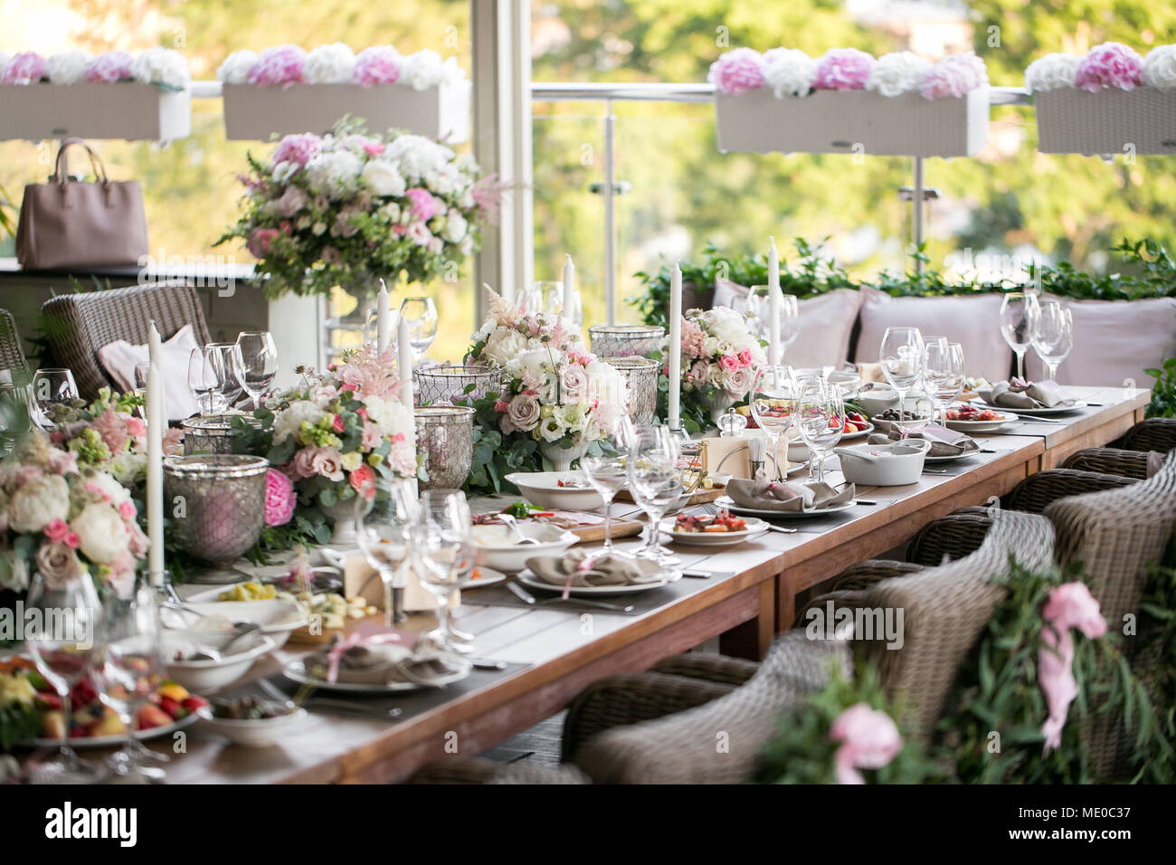 Garland of flowers and greenery for table decoration. Luxury wedding  reception in restaurant. Stylish decor and adorning. White candles on glass  candl Stock Photo - Alamy
