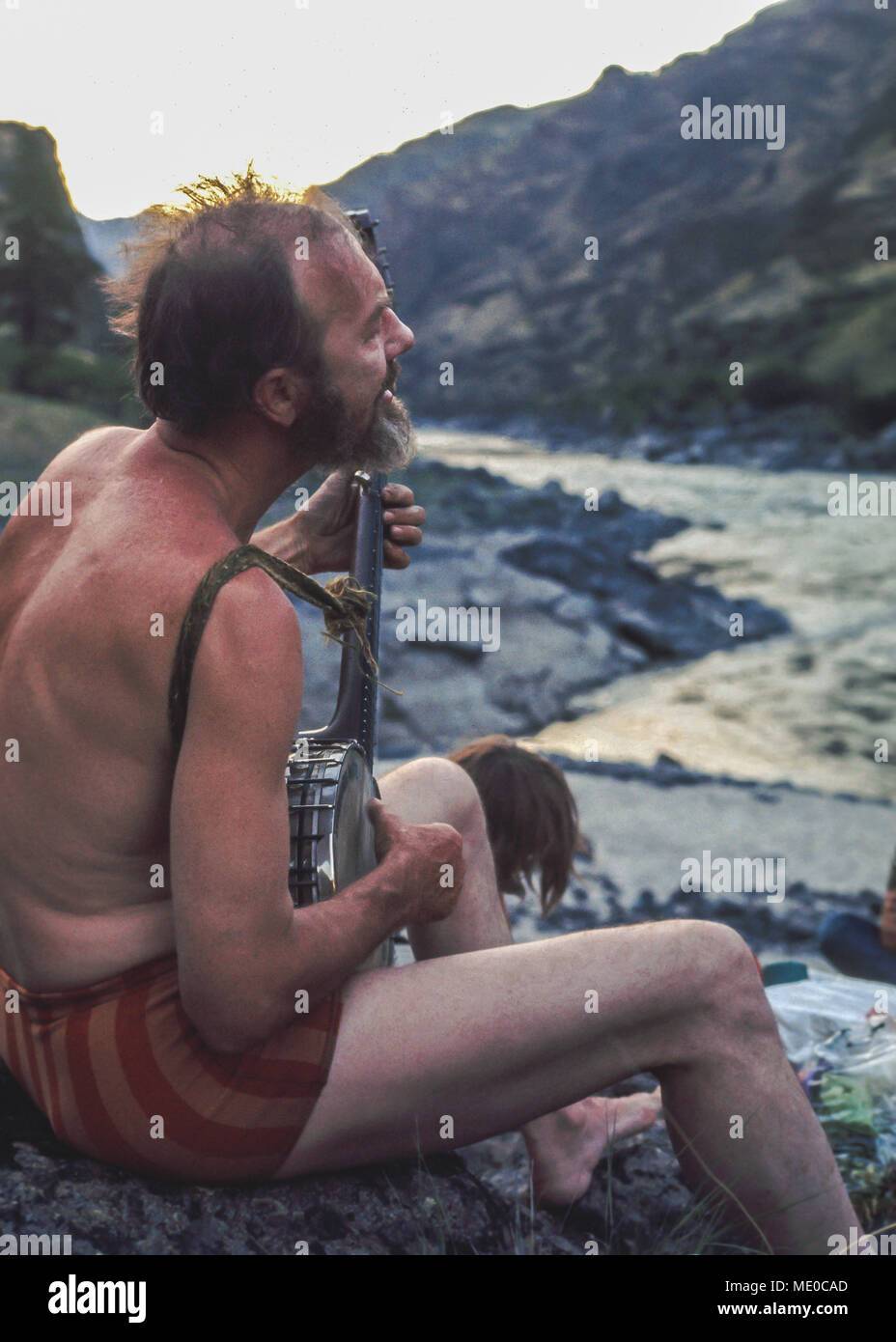 Pete Seeger in Hells Canyon 1972, Snake River; Lettering on his Banjo reads: 'This machine surrounds hate and forces it to surrender.' Pete helped pho Stock Photo