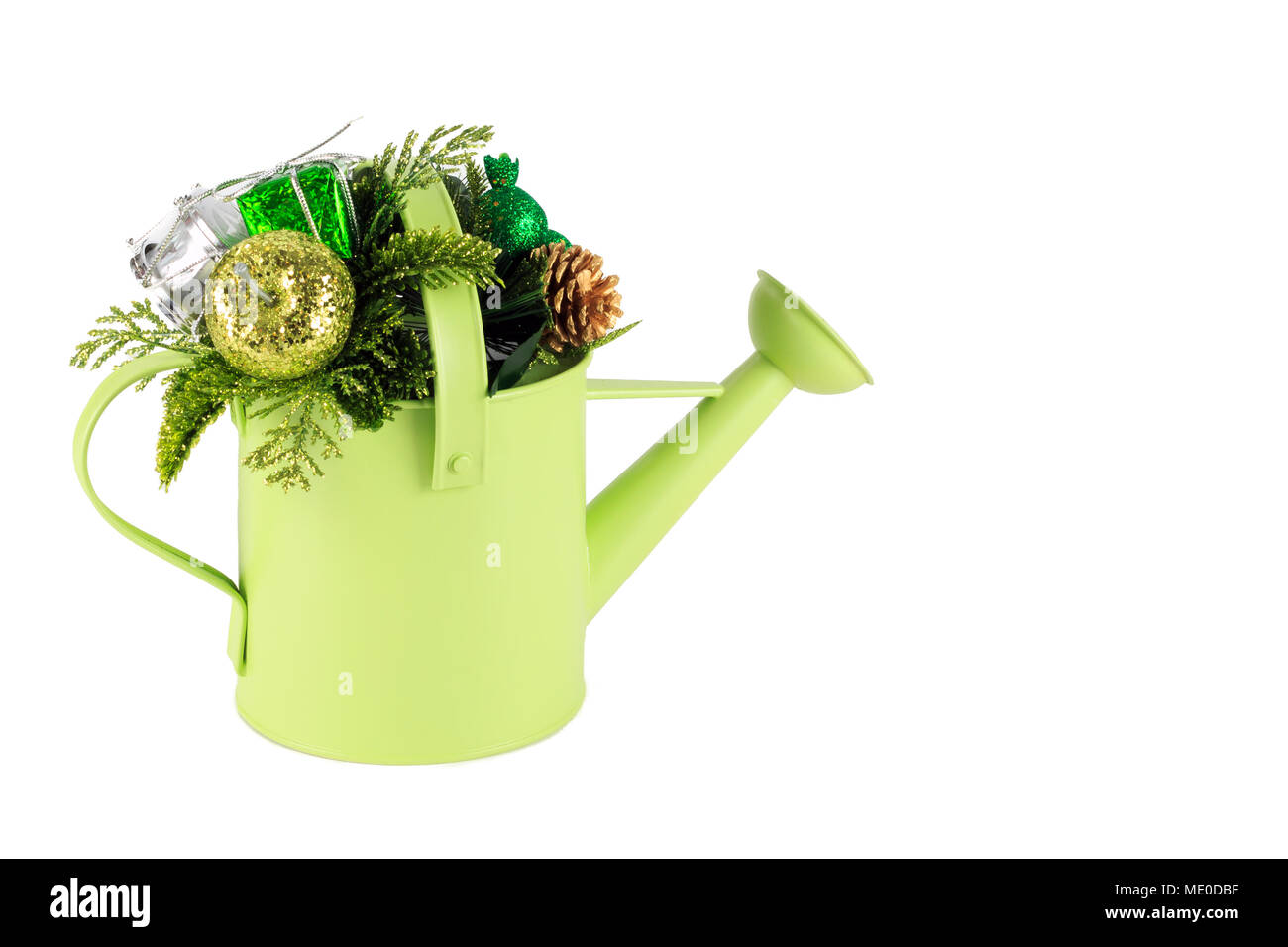 Christmas decorations in small bright green watering can isolated on white background Stock Photo