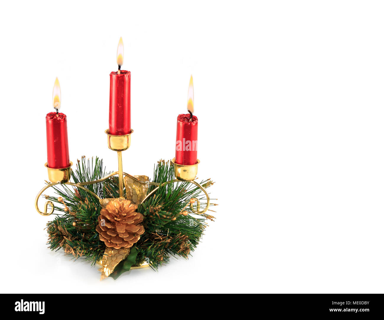 Three Burning Red Candles in Christmas themed decorated brass candle holder  table decoration Stock Photo - Alamy