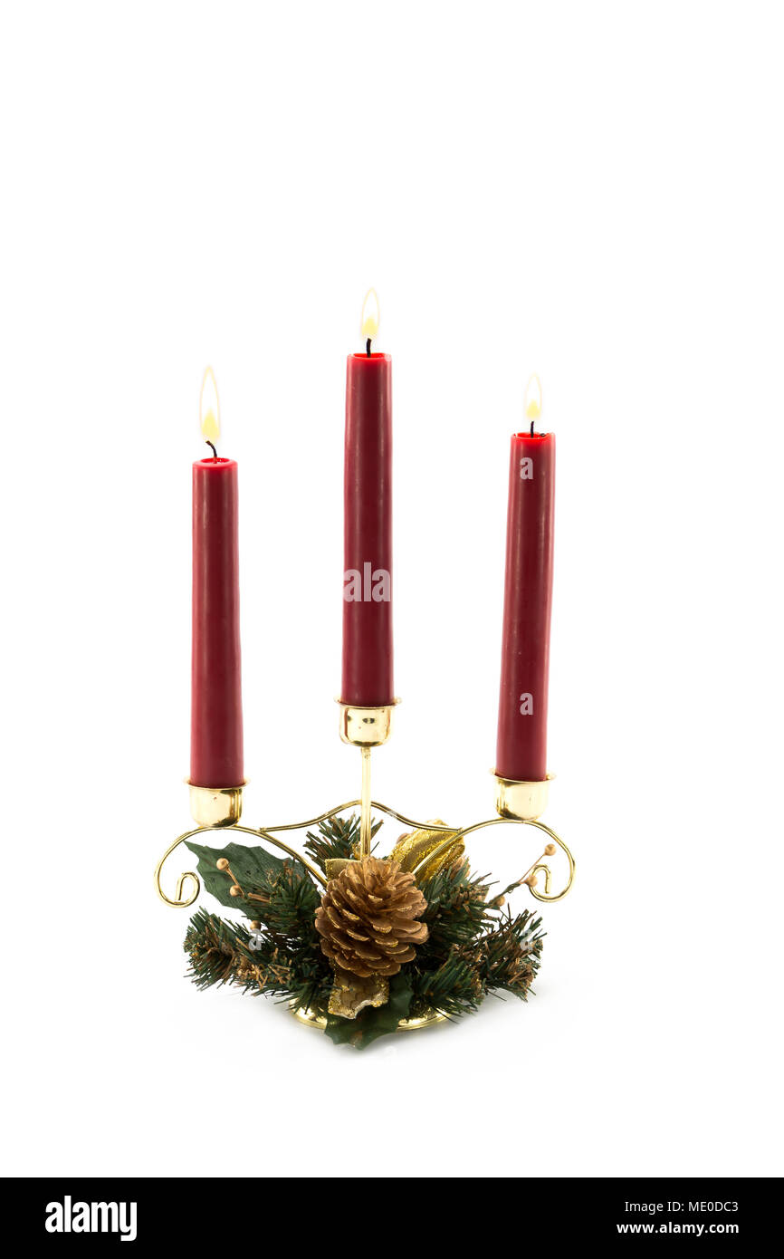 Three Burning Red Candles in Christmas themed decorated brass candle holder table decoration Stock Photo