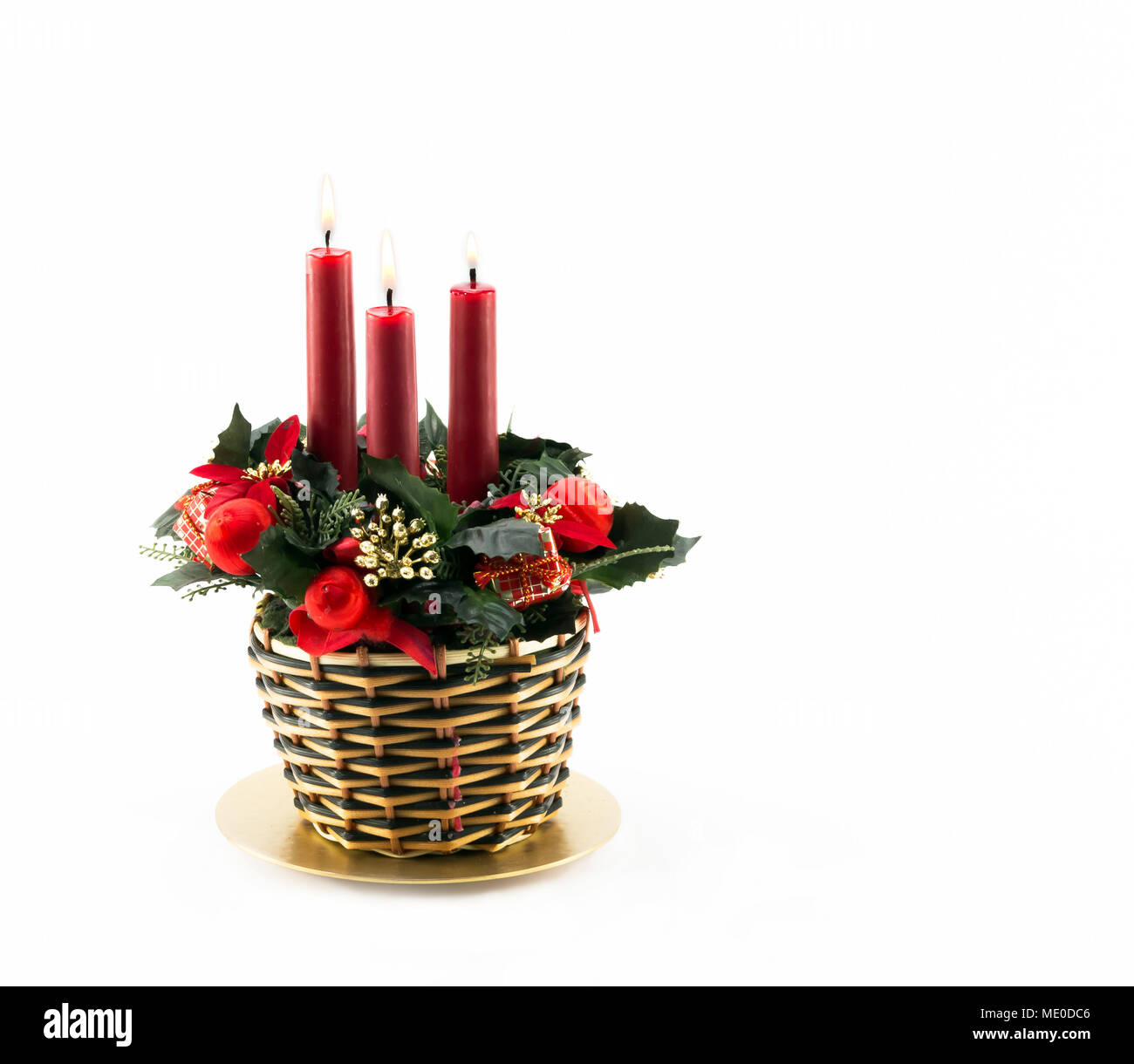 Three Burning Red Candles in Christmas themed decorated wicker basket