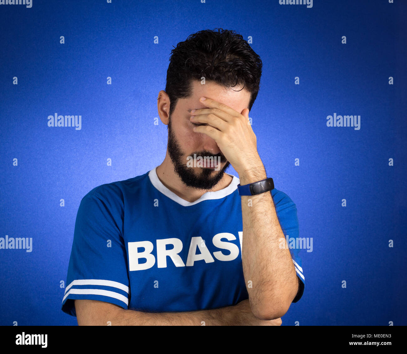Soccer fan in action emotions depressed, worried. Supporter of Brazil