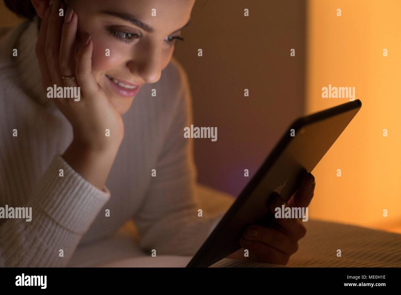 Young woman using digital tablet, smiling. Stock Photo