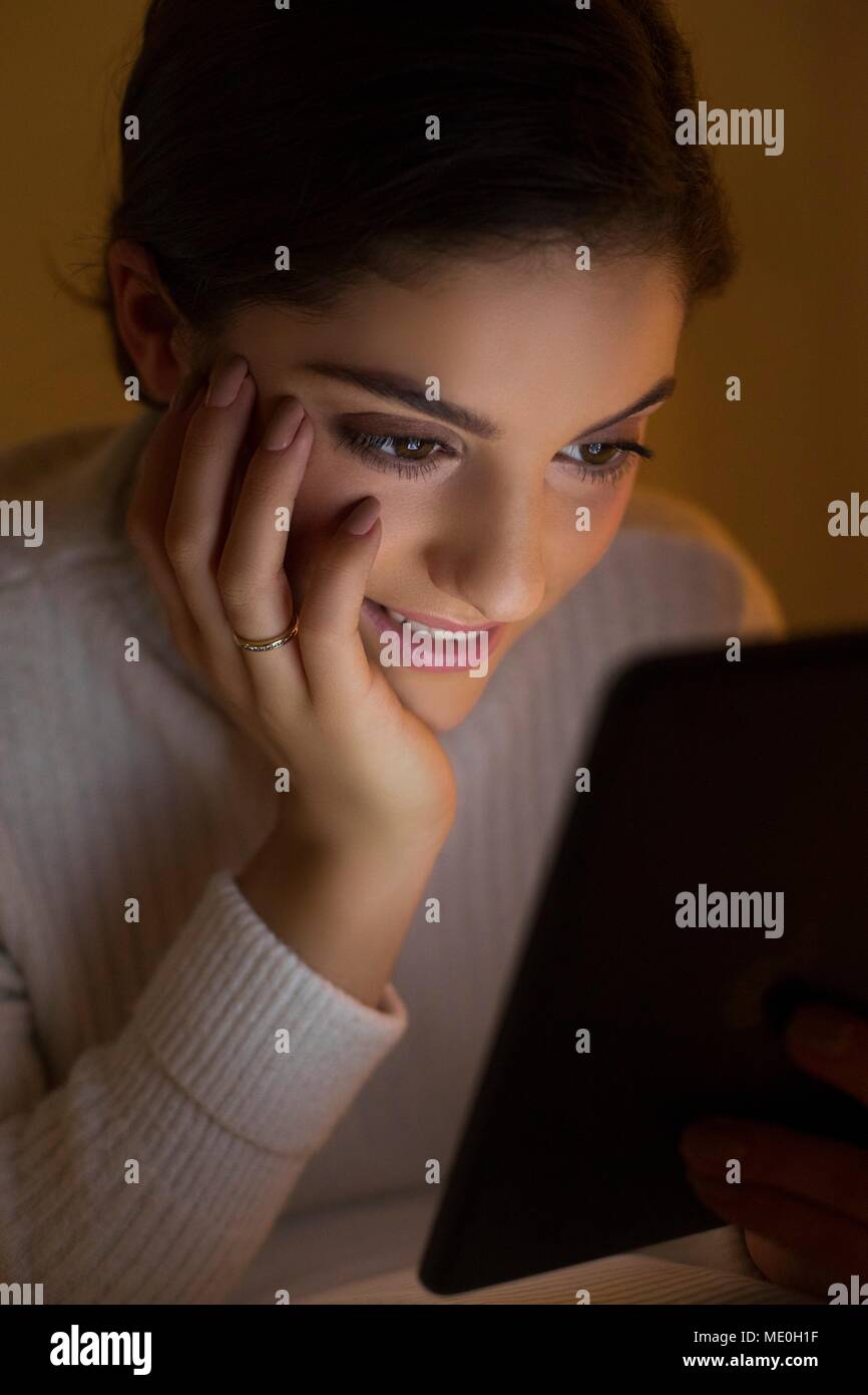 Young woman using digital tablet, smiling. Stock Photo