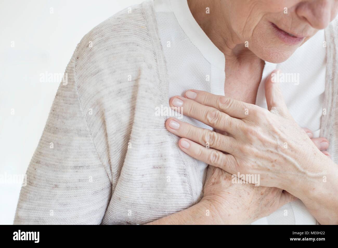 Senior woman holding chest. Stock Photo