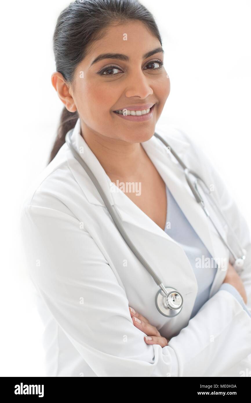 Female doctor smiling towards camera with arms folded, portrait. Stock Photo