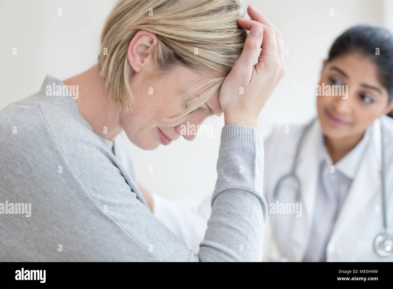 Female doctor listening to patient. Stock Photo