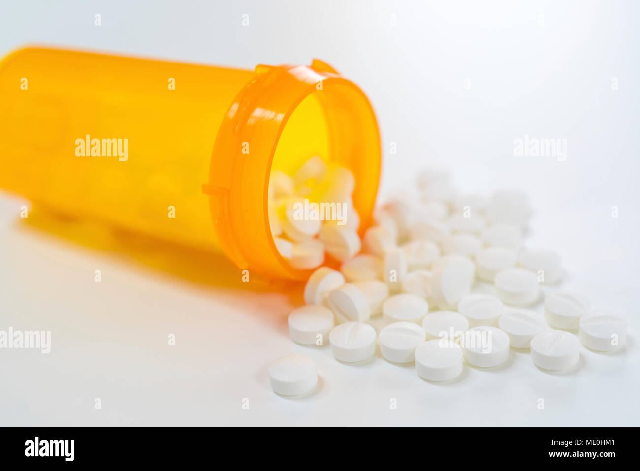 White pills spilling from bottle. Stock Photo