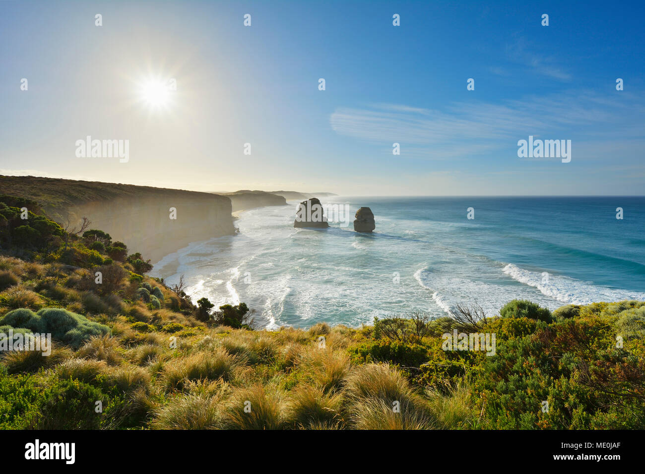 The limestone stacks of the Twelve Apostles backlit by the sun along the Great Ocean Road at Princeton in Victoria, Australia Stock Photo