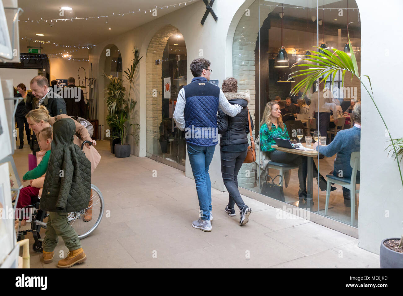 Shoppers walking and browsing outside a restaurant in The Corn Hall