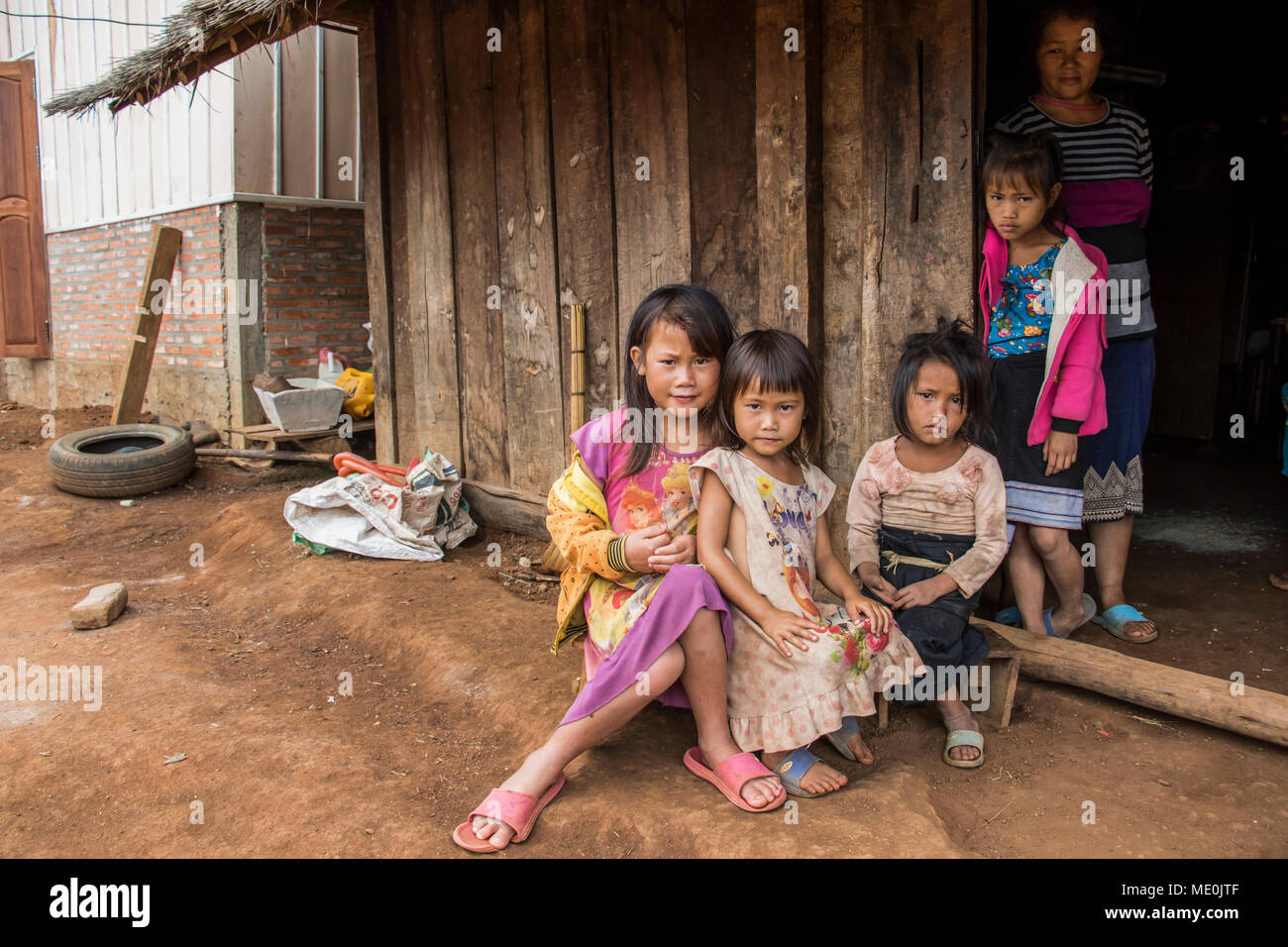 Hmong woman and four girls in front of their house in Na Kam Peng, also called Bomb Village; Xiangkhouang, Laos Stock Photo