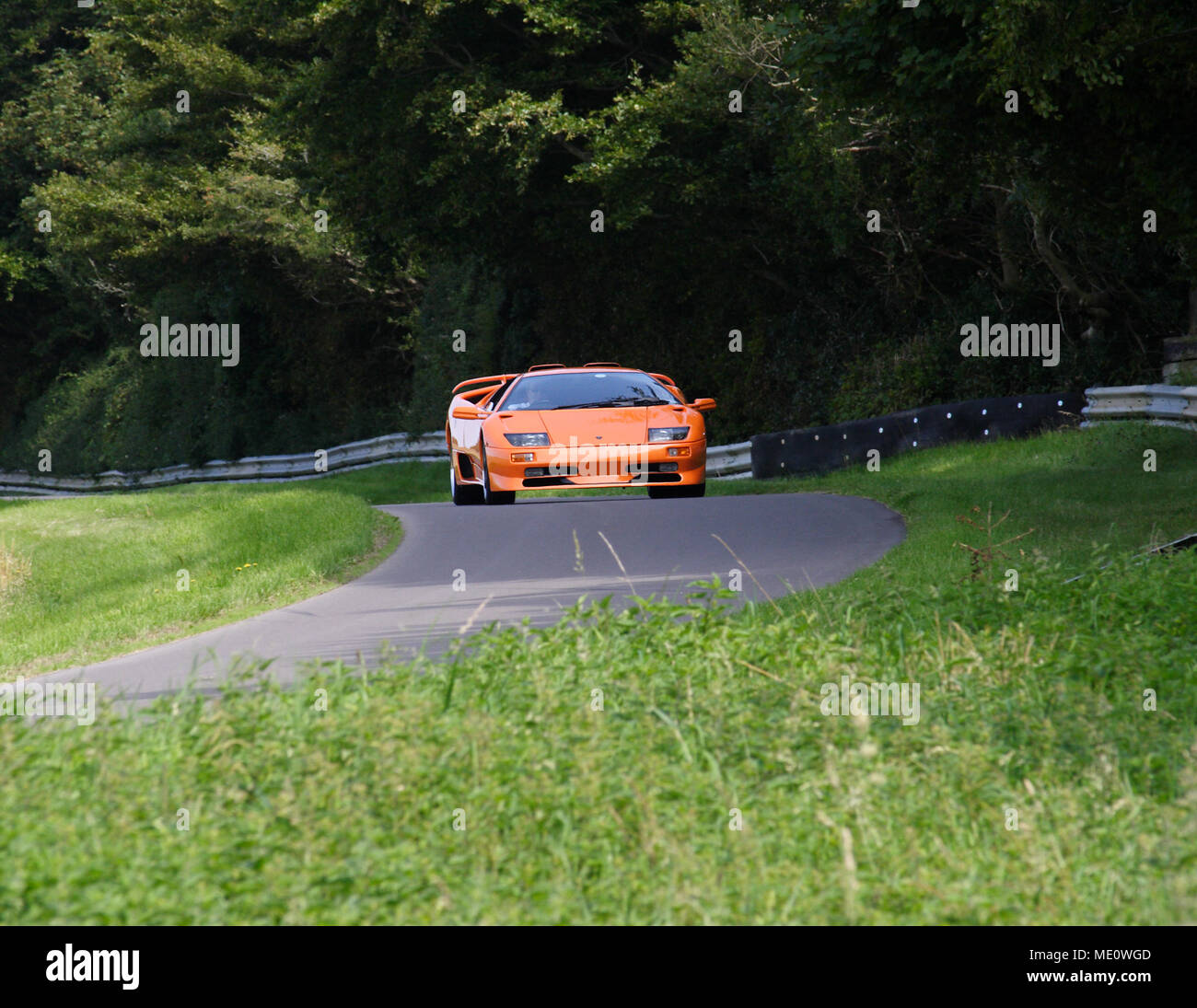 Orange Lamborghini Diablo GT '90s (1990s) V12 supercar driving fast and racing on track. Stock Photo