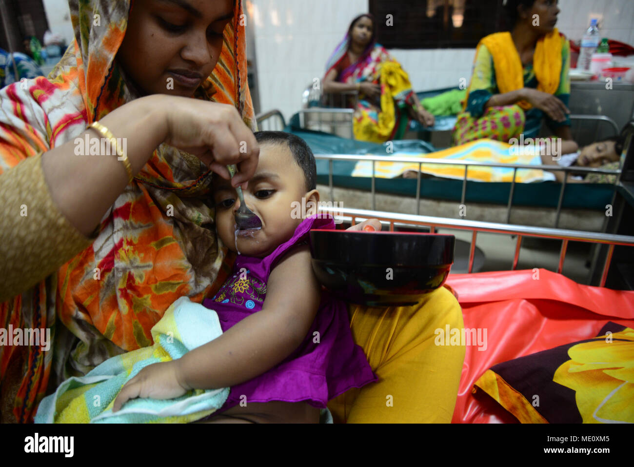 Bangladeshi a mother feeding Saline her children who is suffering from
